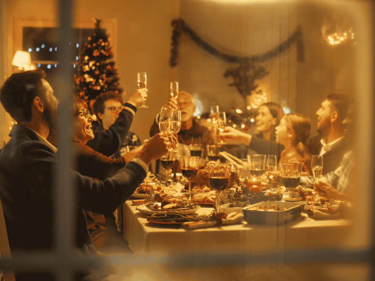 Familie sitzt am Weihnachten zusammen an Esstisch.