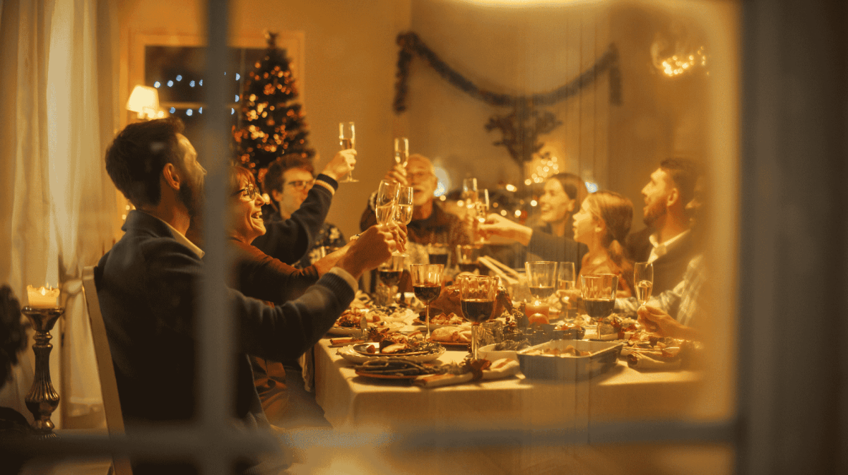 Familie sitzt am Weihnachten zusammen an Esstisch.