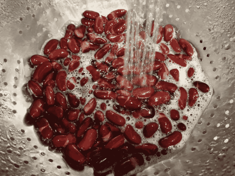 Kidneybohnen in Sieb werden abgespült.