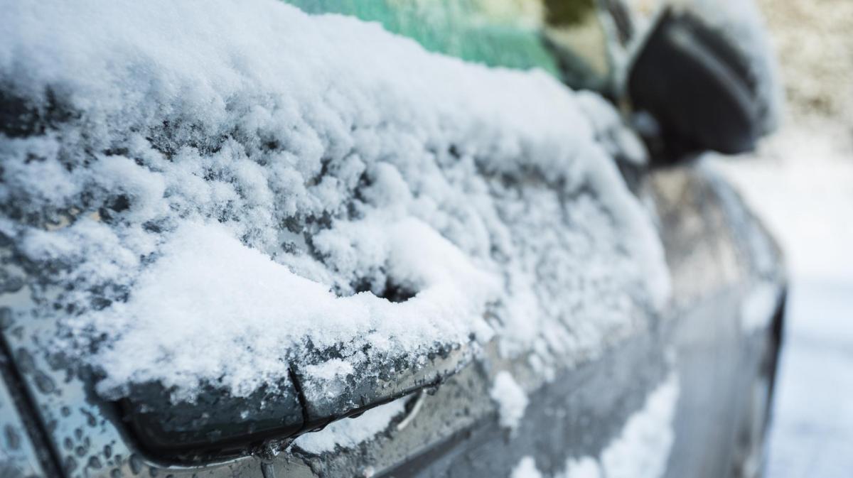 Eine vereiste Autotür mit Schnee.