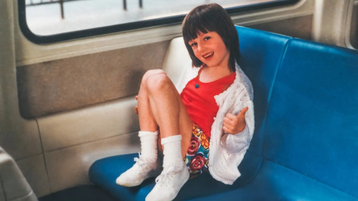 Foto aus den 90ern zeigt ein Mädchen im typischen Look in einer Bahn sitzen.