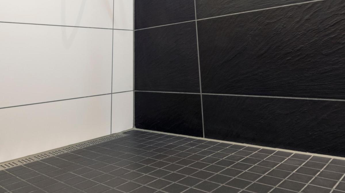 Schwarze Fliesen in der Dusche.