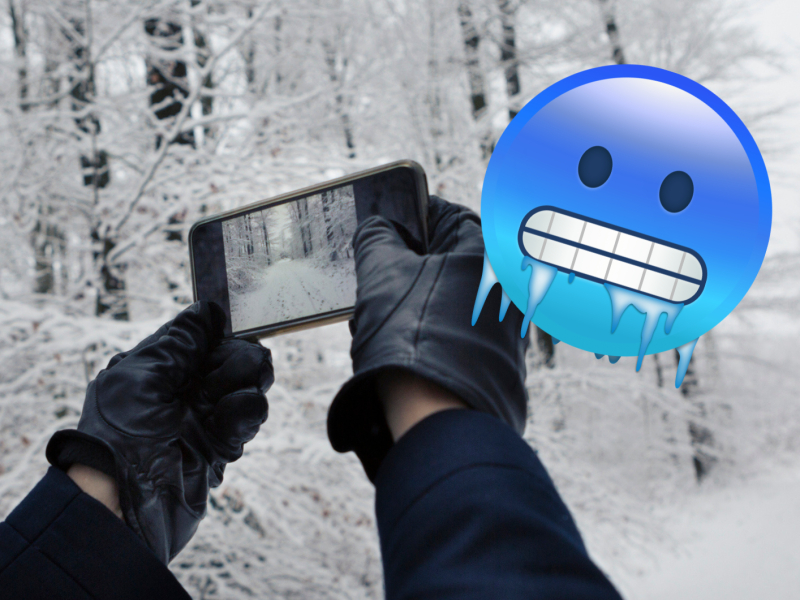 H&auml;nde in Handschuhen halten Smartphone im Winter