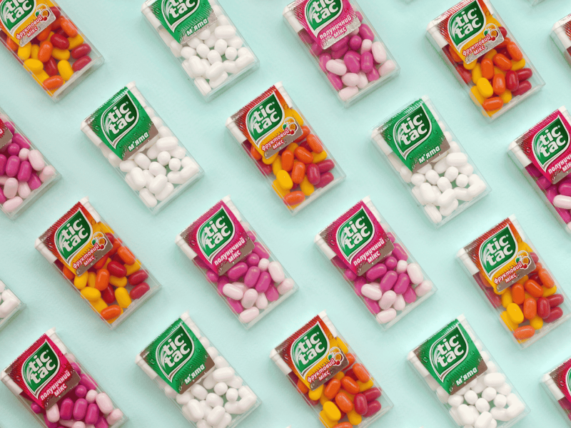 Mehrere Tic-Tac-Packungen liegen auf einem gr&uuml;nen Untergrund.