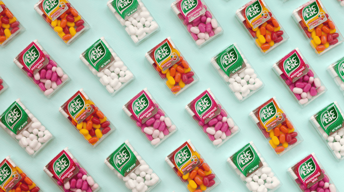 Mehrere Tic-Tac-Packungen liegen auf einem grünen Untergrund.