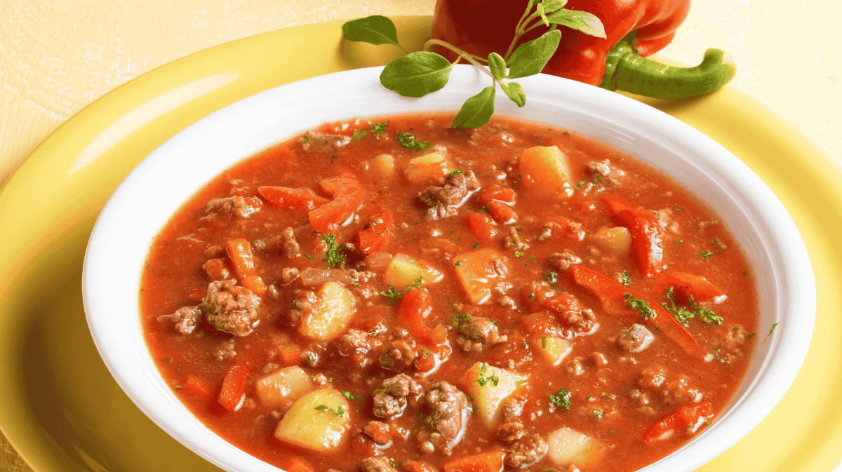 Bauerntopf mit veganem Hackfleisch, Kartoffeln, Paprika und Tomaten in einer weißen Schüssel.