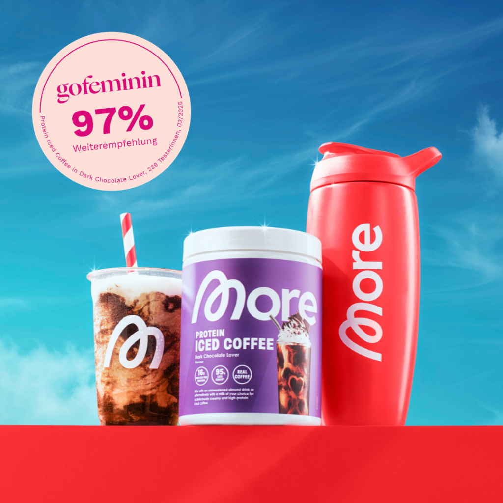 More Protein Iced Coffee in einer lila Dose. Links daneben das fertige Getr&auml;nk im Becher und rechts daneben ein roter Shaker. Im Vordergrund oben links das Testsiegel von gofeminin.
