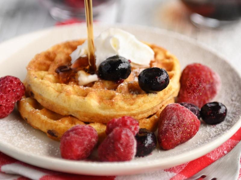 Mini-Waffeln auf einem Teller mit Fr&uuml;chten.
