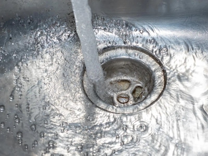 Wasser flie&szlig;t in den Abfluss im Sp&uuml;lbecken in der K&uuml;che.
