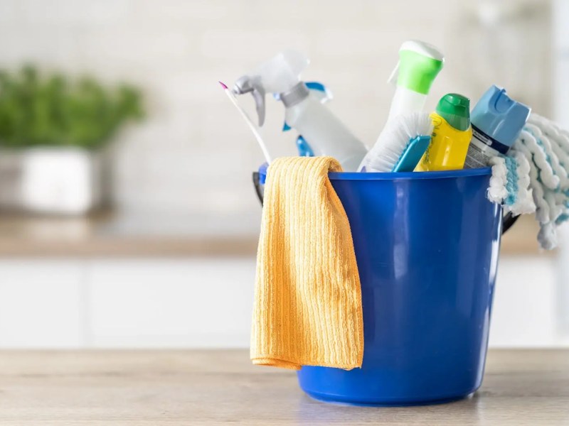 Blauer Putzeimer mit verschiedenem Putzmittel.