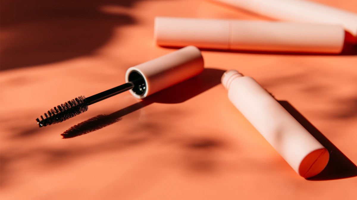 Wimperntusche, die offen auf einem Tisch liegt.