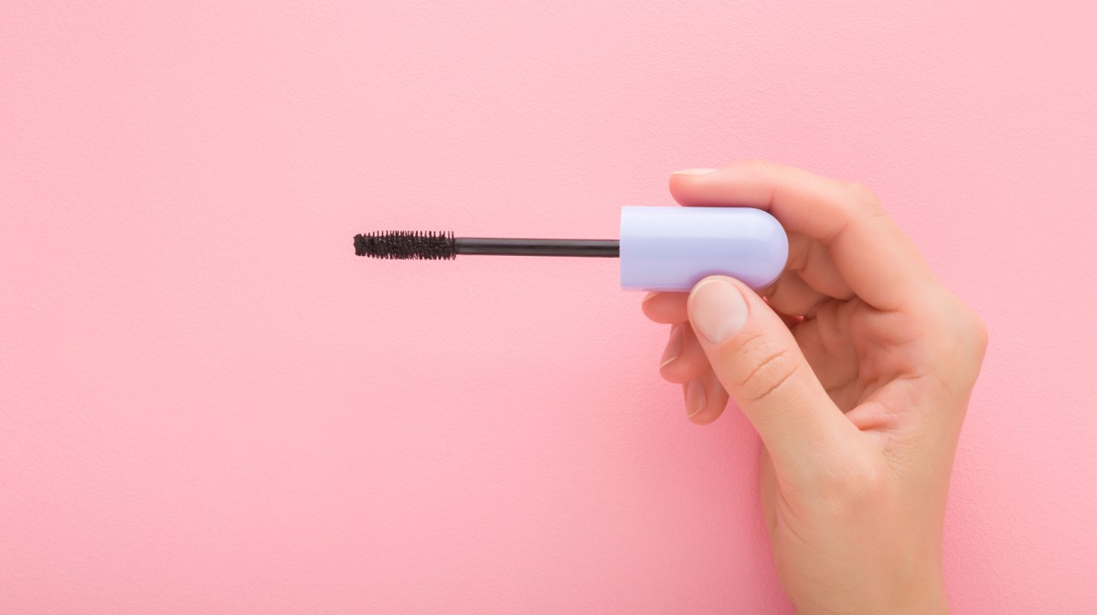 Mascara-Bürstchen vor rosa Hintergrund.