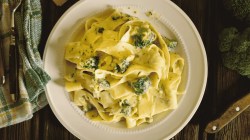 Tagliatelle mit Brokkoli-K&auml;se-So&szlig;e auf Teller.