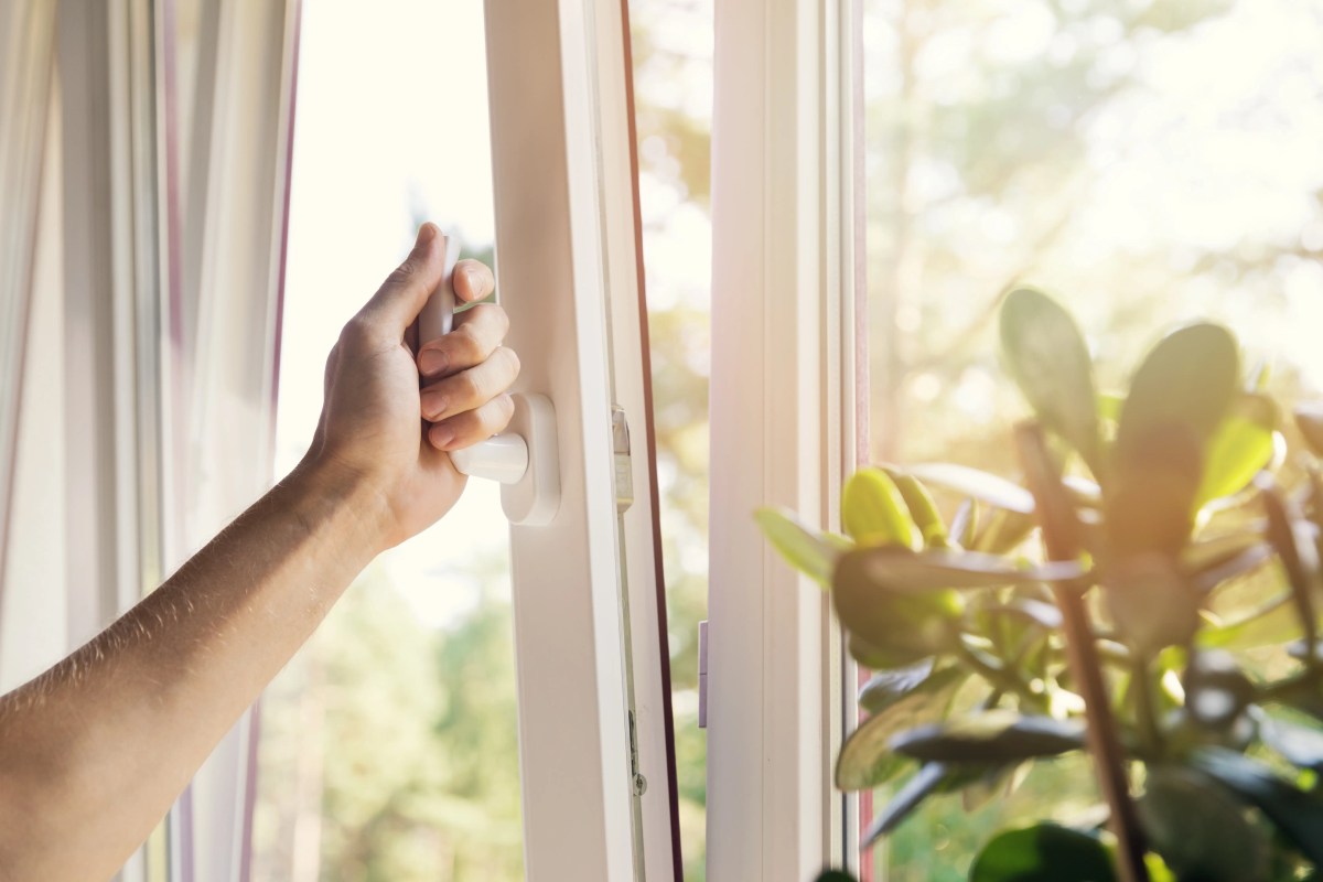 Frauenhand öffnet ein Fenster auf Kipp