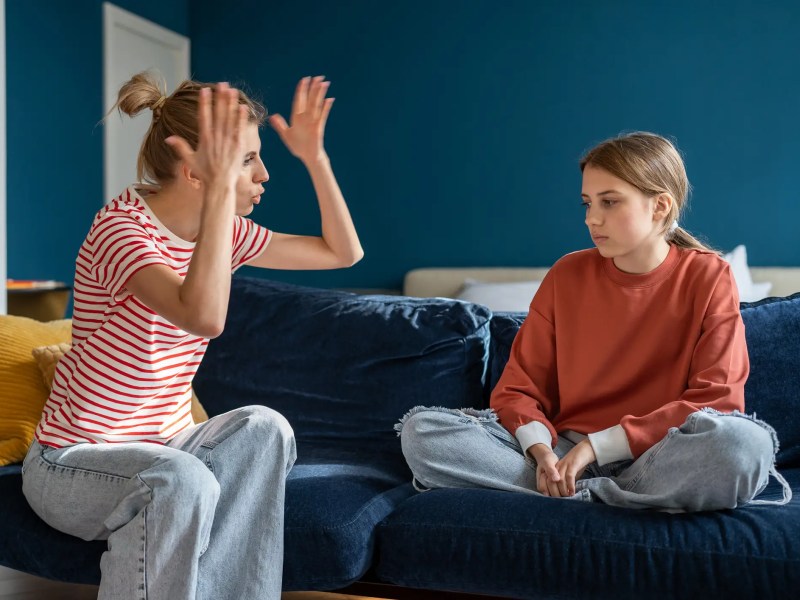 Teenager Mädchen sitzt mit ihrer Mutter auf der Couch und streitet sich
