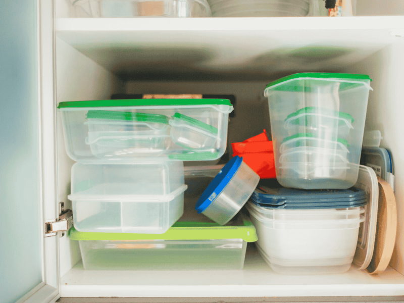Voller K&uuml;chenschrank mit Plastikbeh&auml;ltern.