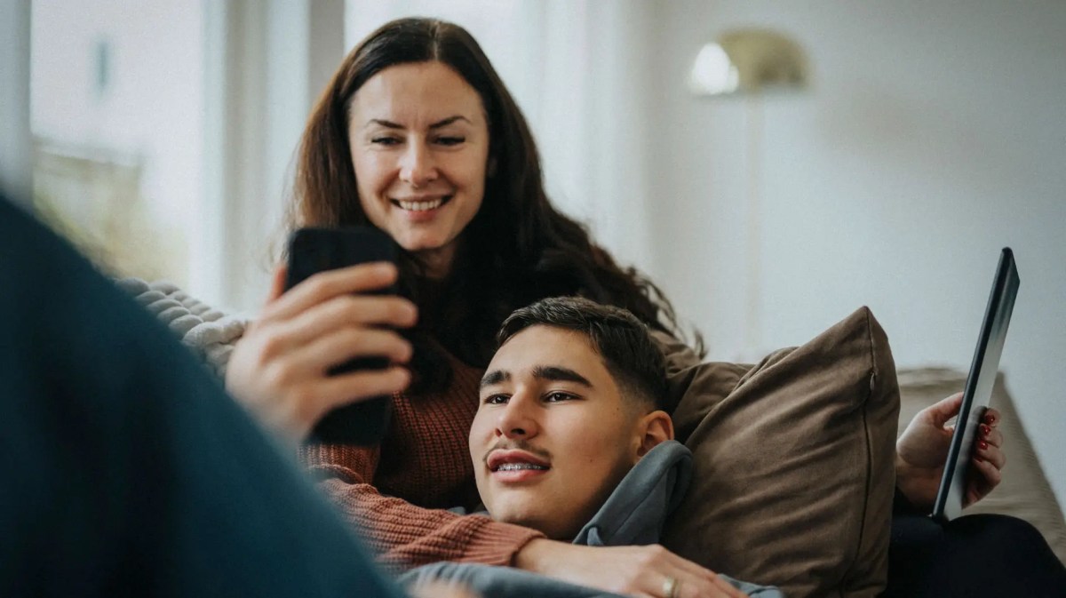 Mutter und Sohn im Teenie-Alter chillen zusammen auf dem Sofa.