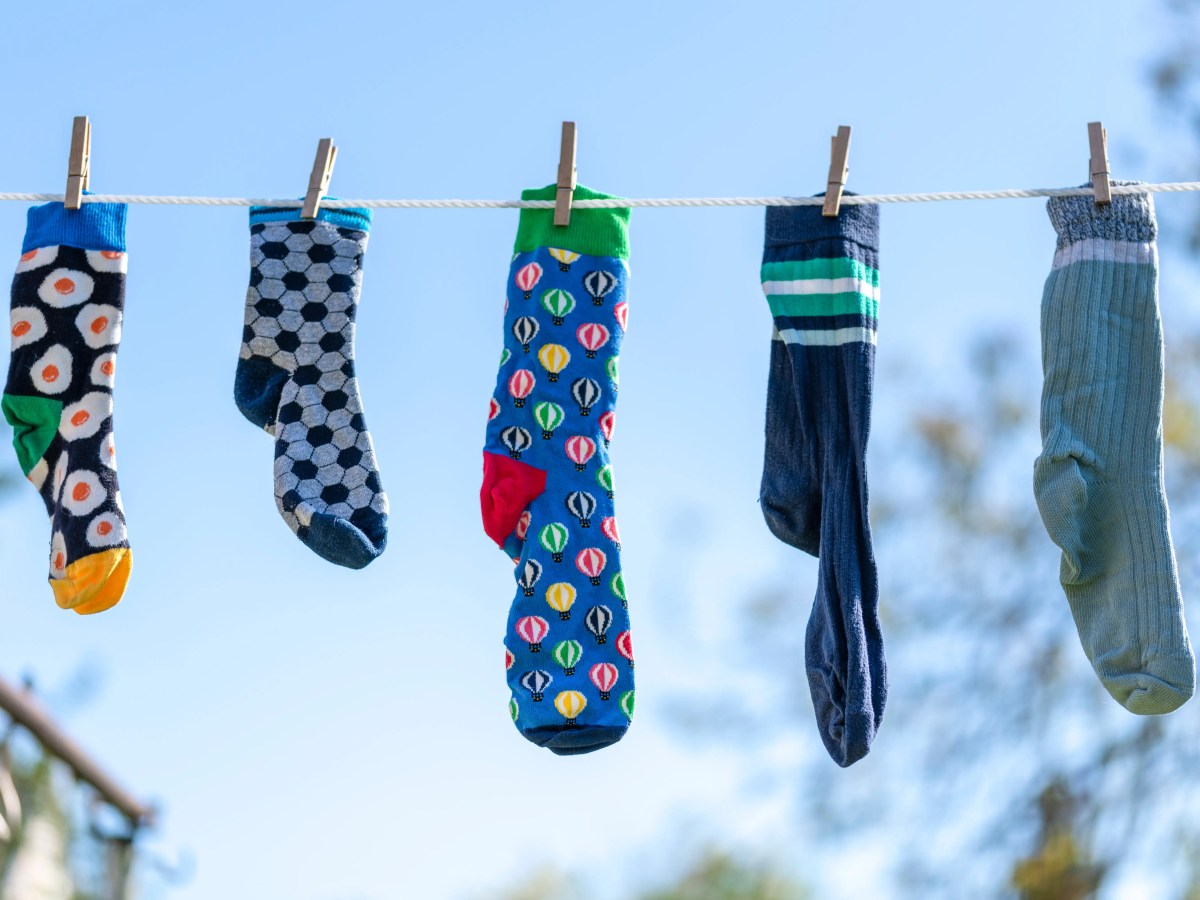 Verschiedene bunte Socken hängen draußen an der Wäscheleine