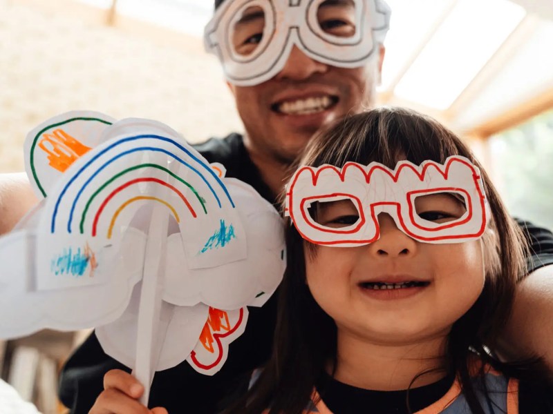Tochter und Vater habn Masken gebastelt und machen ein Selfie.