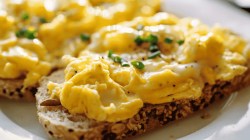 Gl&auml;nzendes R&uuml;hrei auf einem K&ouml;rnerbrot.