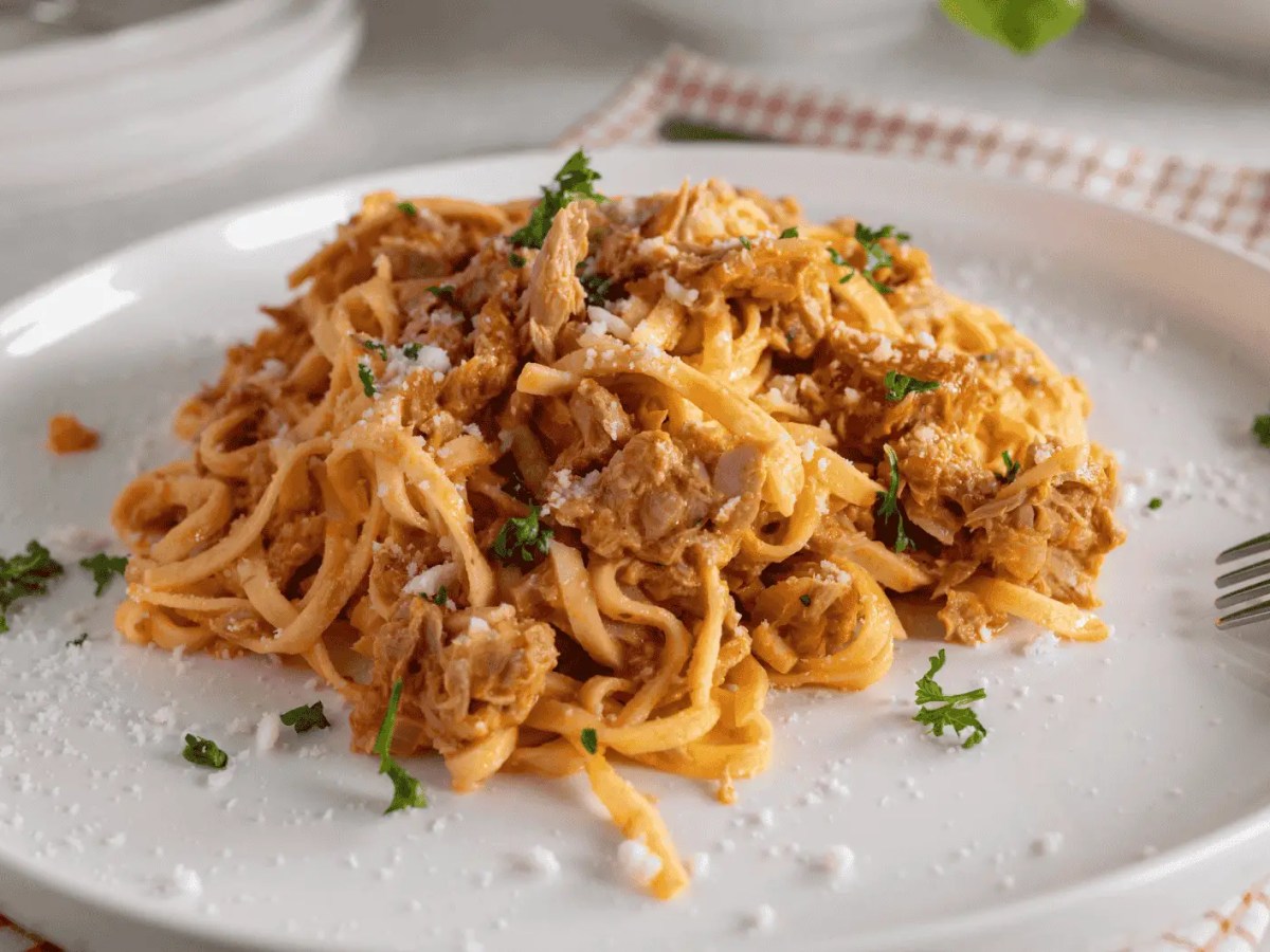 Teller mit Tagliatelle in einer Tomaten-Thunfisch-Soße.