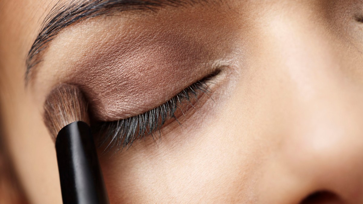 Close up of young woman applying eye shadow