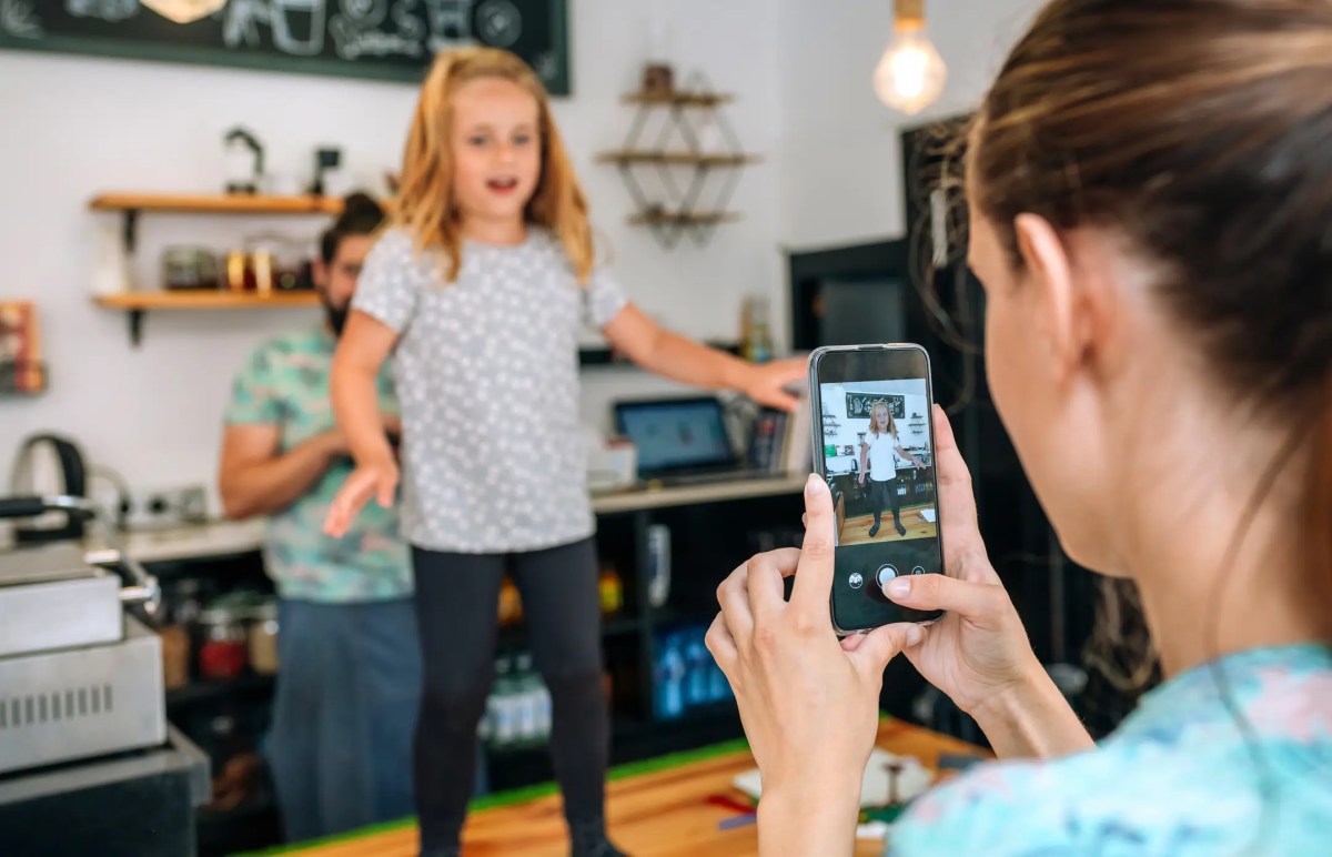 Mutter filmt ihre Tochter beim Tanzen mit dem Smartphone