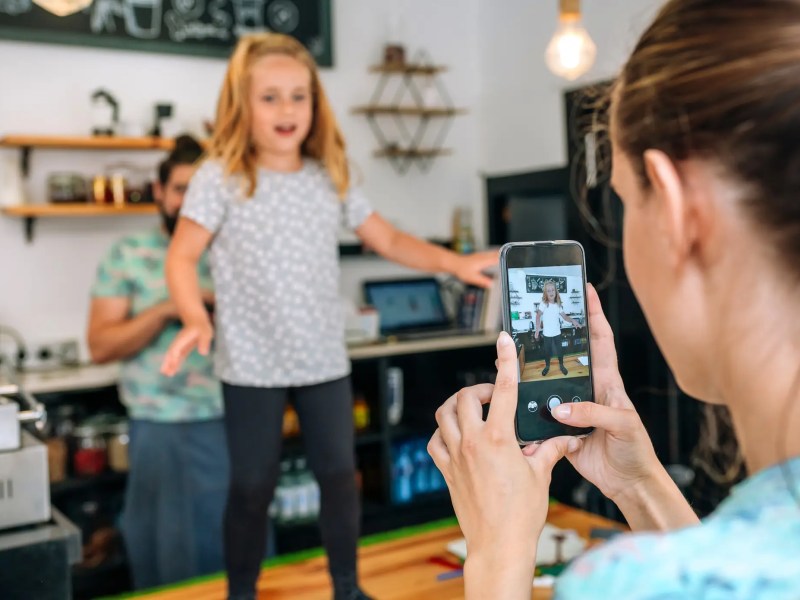 Mutter filmt ihre Tochter beim Tanzen mit dem Smartphone