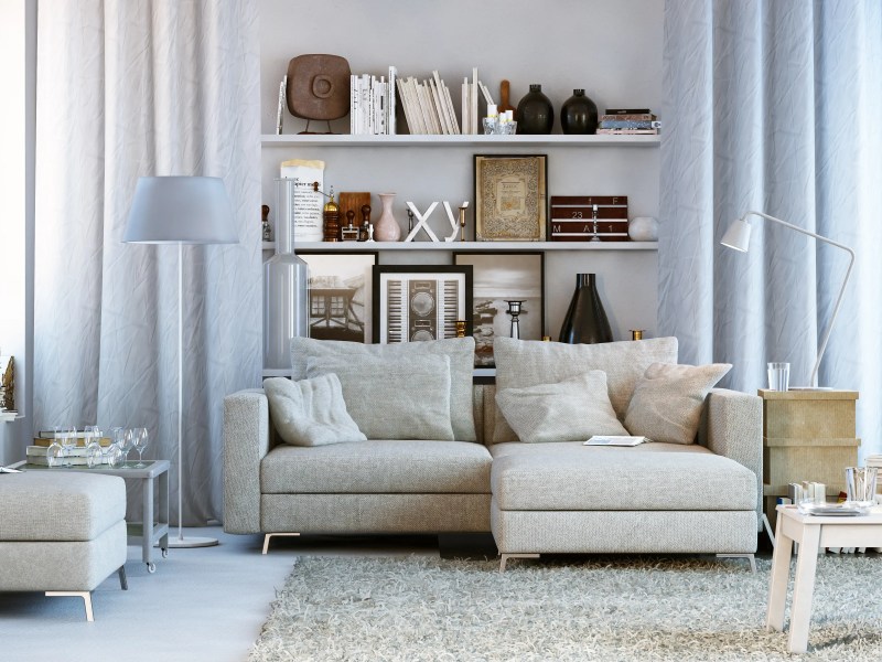 Modernes Wohnzimmer mit Regalen, Bücherdeko und in weiß gehalten.