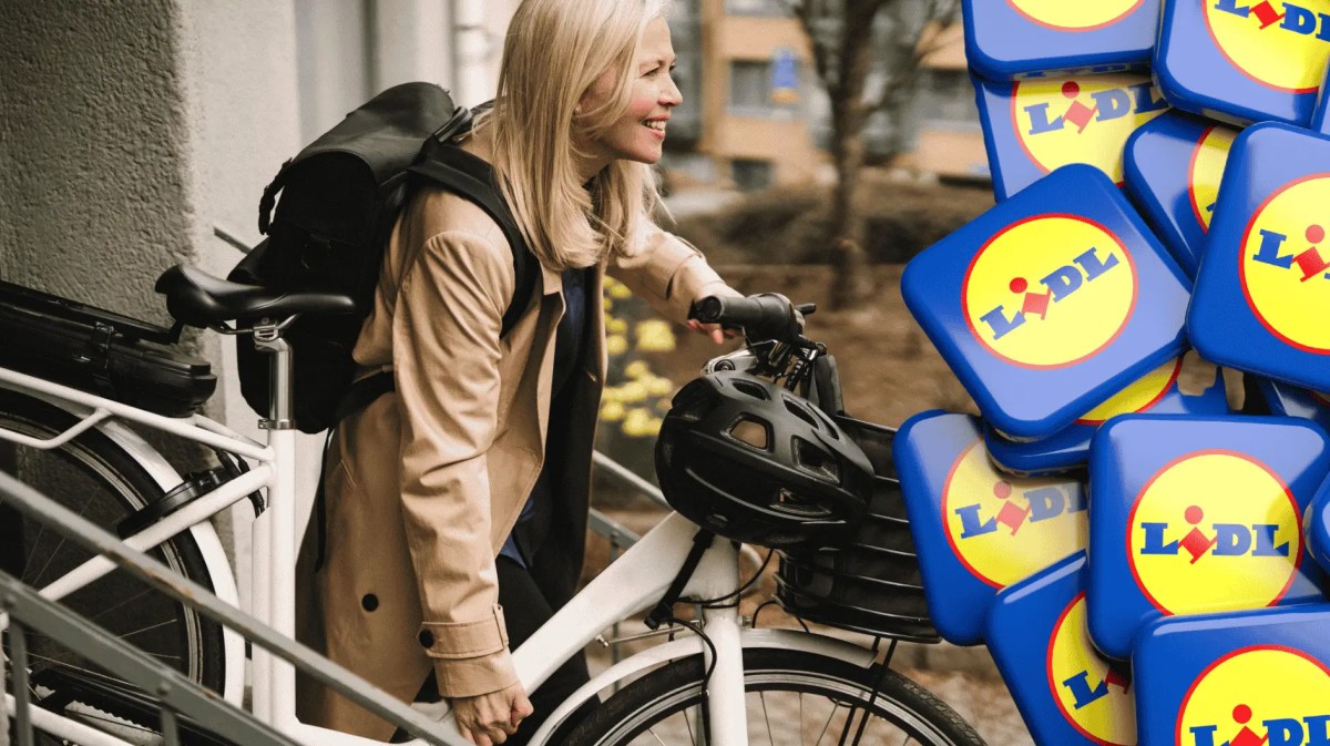 Frau trägt ihr E-bike nach draußen.
