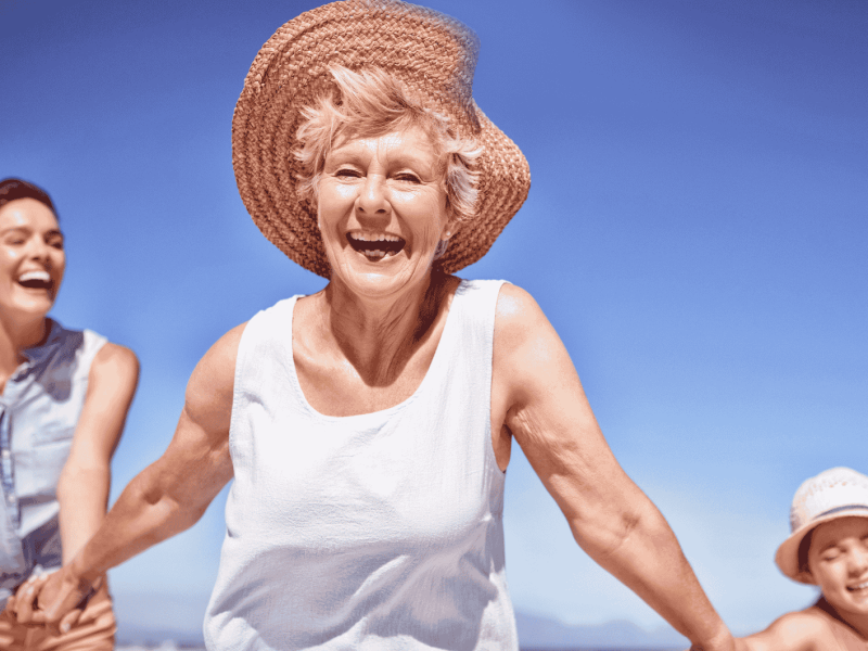 Familie mit Gro&szlig;mutter l&auml;uft am Strand.