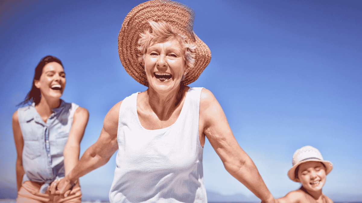 Familie mit Großmutter läuft am Strand.