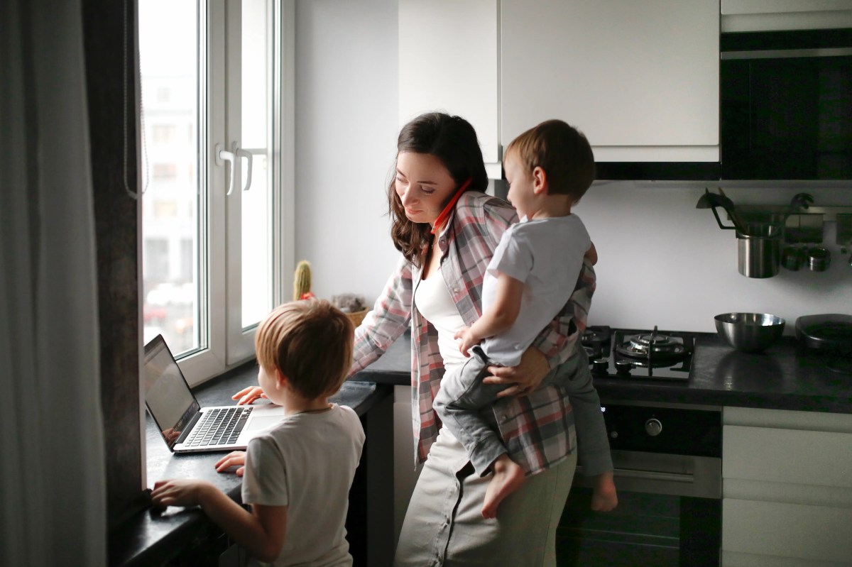 Gestresste Mutter mit zwei Kindern und einem Handy am Ohr