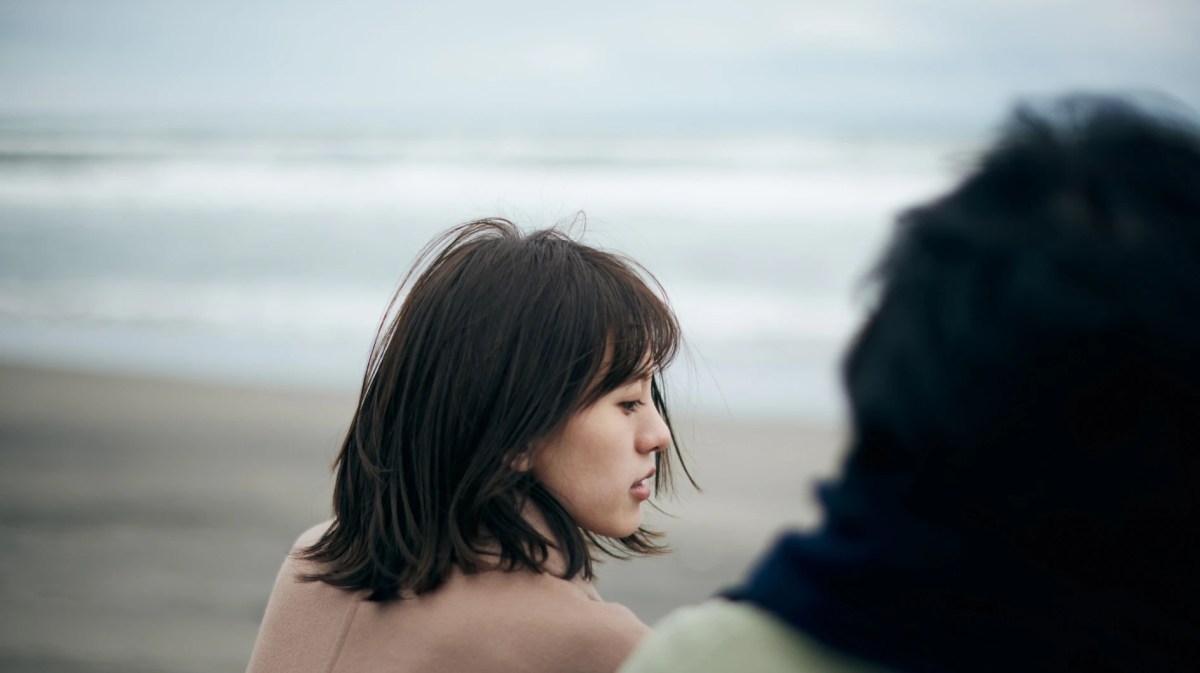 Zwei Frauen sitzen am Meer und blicken ernst