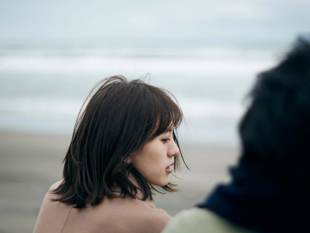 Zwei Frauen sitzen am Meer und blicken ernst