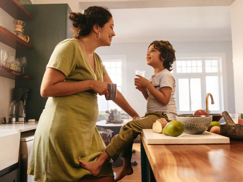 Mutter und Sohn sitzen in der Küche und lachen sich an