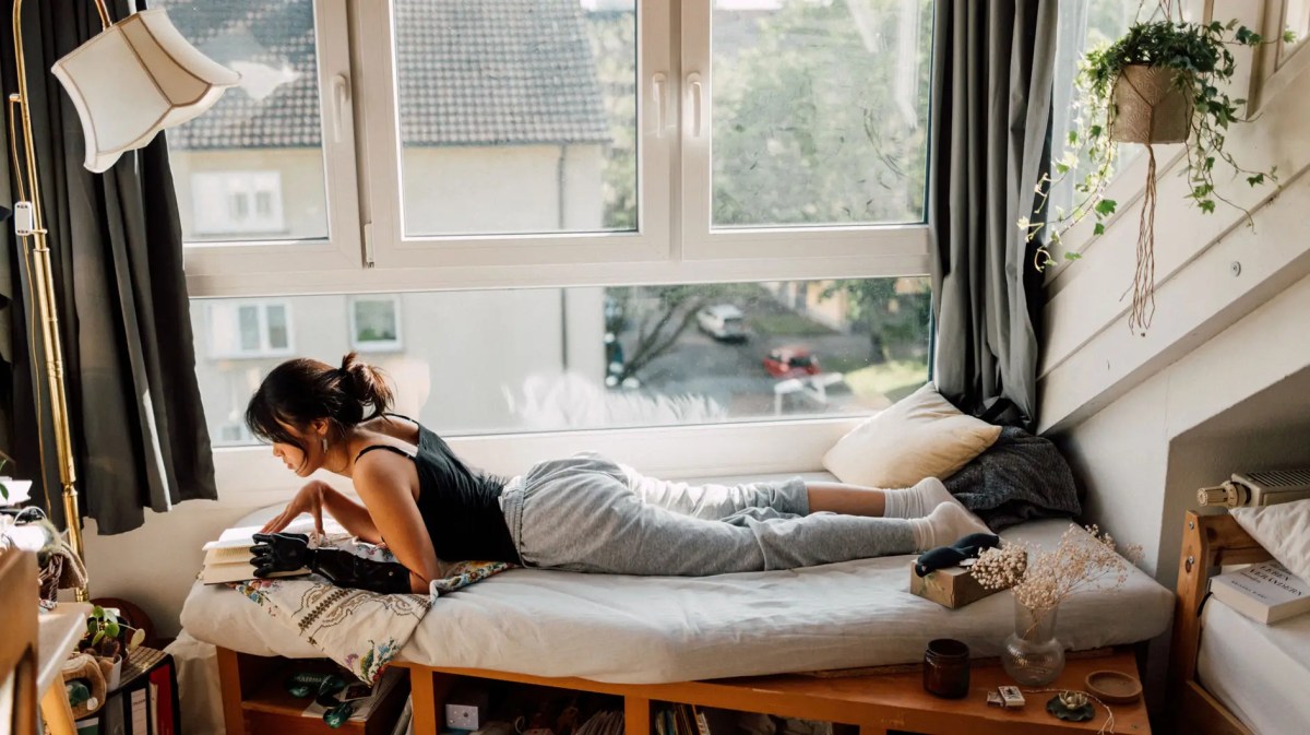 Teenagermädchen liegt am Tag auf ihrem Bett und liest.
