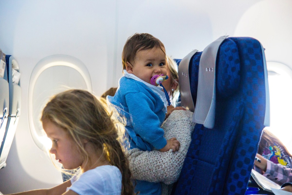 Mutter mit zwei Kleinkindern sitzen im Flugzeug