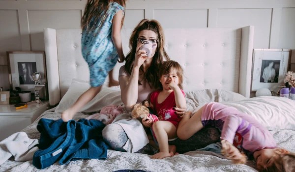 Mutter mit Kindern auf dem Bett