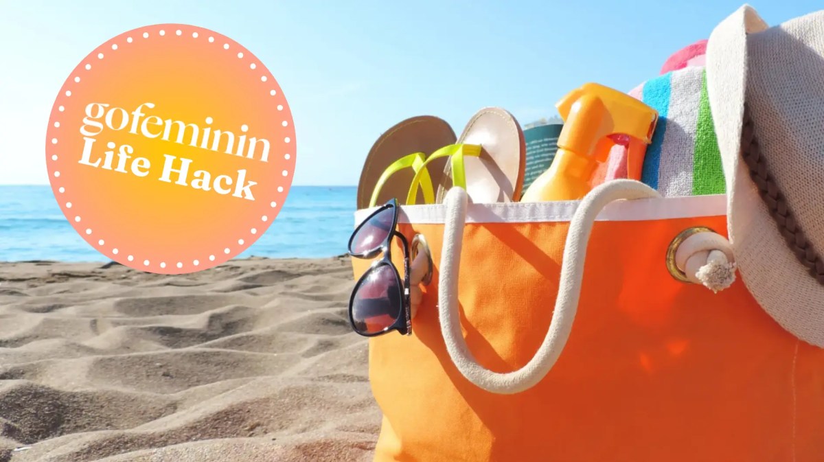 Strandtasche in Orange steht am Strand mit dem gofeminin Logo