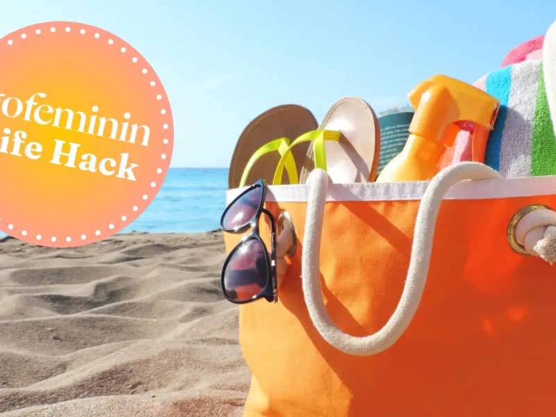 Strandtasche in Orange steht am Strand mit dem gofeminin Logo