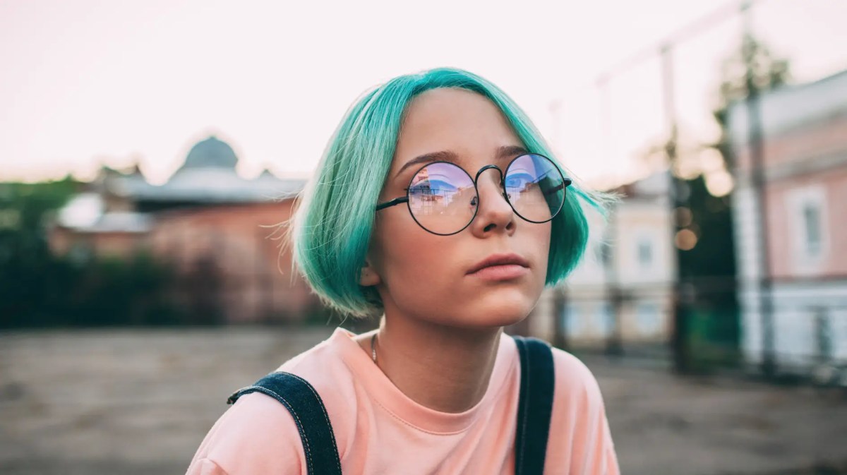 Porträt eines Teenagermädchens mit grünlich-blauen Haaren.