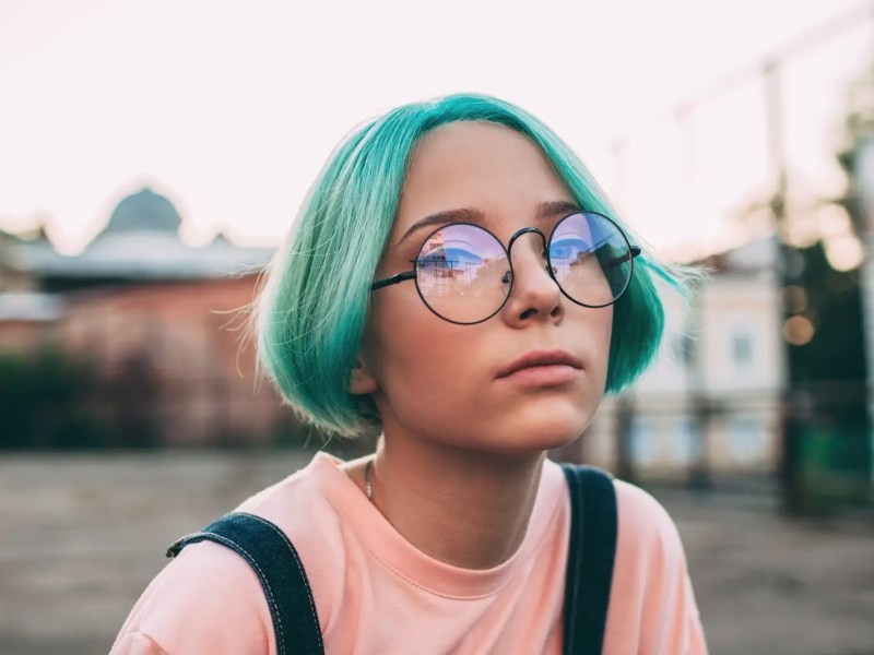 Porträt eines Teenagermädchens mit grünlich-blauen Haaren.